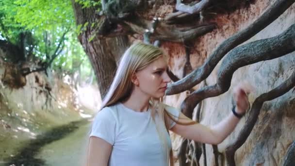 金发碧眼的年轻女子凝视着天然黄土高原的树根 — 图库视频影像