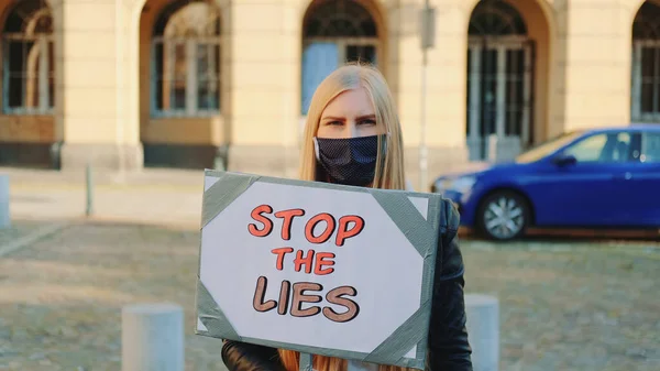 戴面具的女人高举抗议标语叫停谎言 — 图库照片