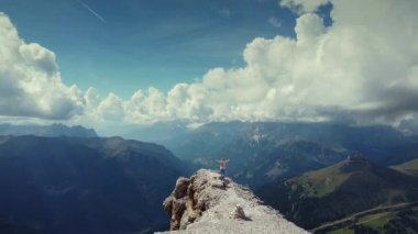 Piz Boe dağının tepesinde ellerini kaldırmış bir kadının üzerinde destansı bir uçuş.