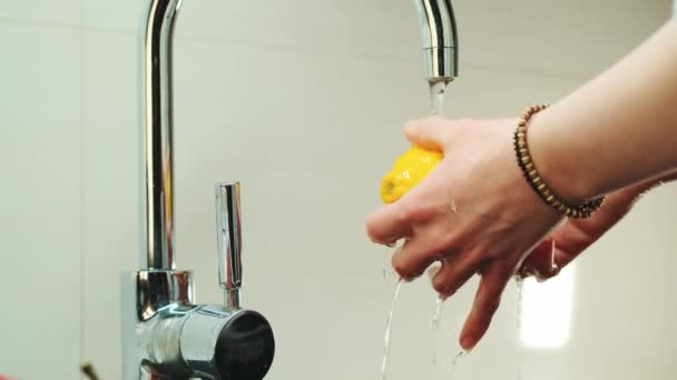 女性の手は水でタップの下にレモンを洗う — ストック動画