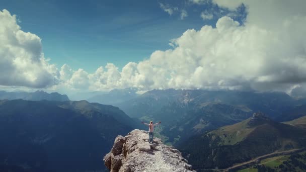 Voando sobre a mulher com as mãos levantadas em pé no topo da montanha Piz Boe em Dolomitas — Vídeo de Stock