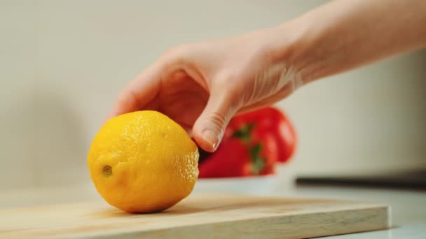 Mãos com faca de corte de limão na placa da cozinha — Vídeo de Stock