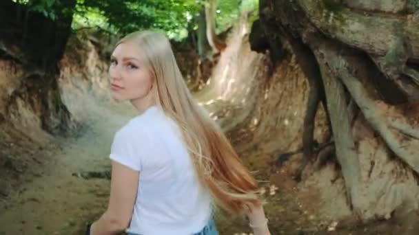 Vue arrière de jolie femme blonde courant dans Roots Gorge — Video