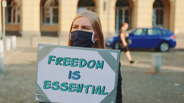Mujer enmascarada en marcha de protesta llamando a la libertad es esencial — Foto de Stock