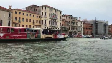 Turistler Venedik 'te tekneyle geziyorlar.
