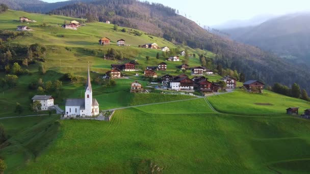 Flygfoto över villor och kyrka på österrikiska berg — Stockvideo