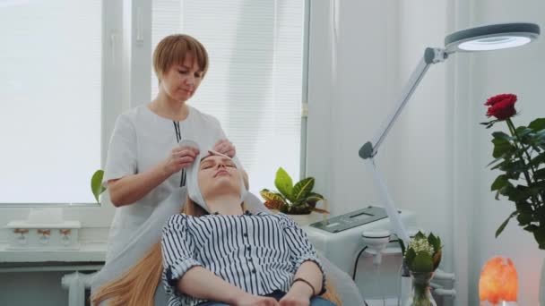 Kosmetička připravuje ženu na čištění obličeje v salonu krásy — Stock video
