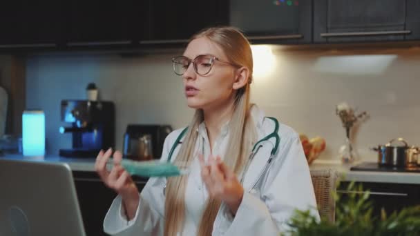 Médica mostrando como usar máscara médica por videochamada no computador — Vídeo de Stock