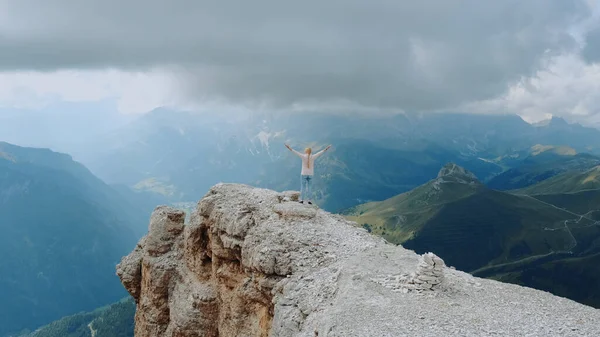 Fantastická krajina horských skal a ženy stojící na vrcholu s nataženýma rukama — Stock fotografie