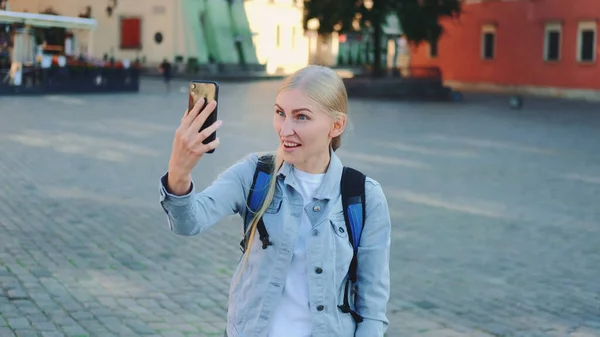 Kadın turist, ziyaretinin olduğu yerden akıllı telefondan video görüşmesi yapıyor. — Stok fotoğraf