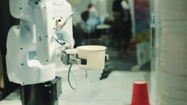 Robot with artificial intelligence making coffee on coffee machine