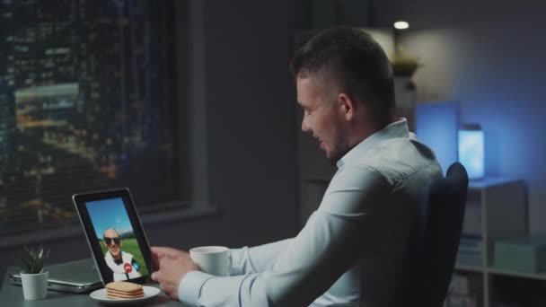 Joven hombre usando tableta para hacer videollamada con su novia — Vídeos de Stock