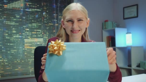 Happy young woman presenting gift to the camera and smiling — Stock Video