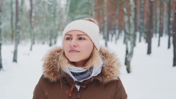 Nevando na floresta: mulher de roupas de inverno andando e admirando a natureza — Vídeo de Stock