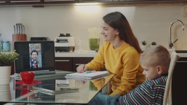 Робота в домашньому офісі: жінка робить відеодзвінок на ноутбук зі своїм колегою з іншої країни — стокове відео