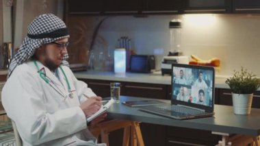 Online meeting on coronavirus infection: arab doctor with kandora listening to the experience of specialists from neighboring countries