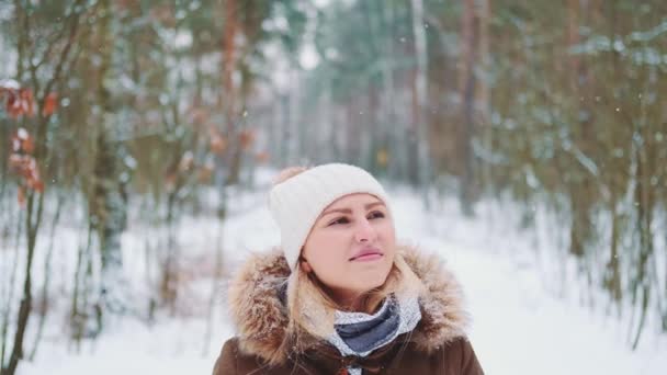 Mujer bonita en invierno caminando y admirando el bosque nevado. — Vídeos de Stock