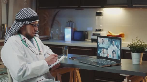Online meeting on coronavirus infection: arab doctor with kandora listening to the experience of specialists from neighboring countries — Vídeo de Stock