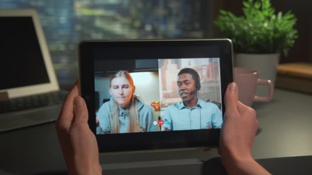 Online videovergadering op tablet: gemengde man en vrouw spreken over iets — Stockvideo