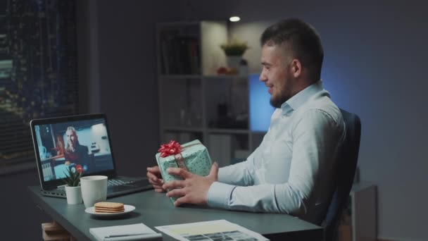 Multiracial man and woman making online video meeting to open the received presents from each other. — Video Stock