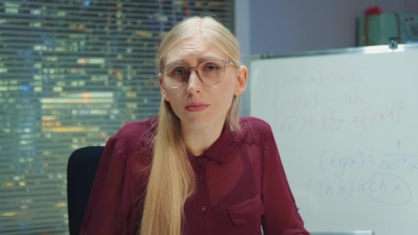 Portret uitzicht van blonde vrouw in bril spreken tot de camera — Stockvideo