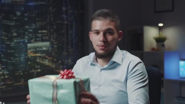 Knappe jongeman met baard presenteert speciaal cadeau aan de camera — Stockvideo