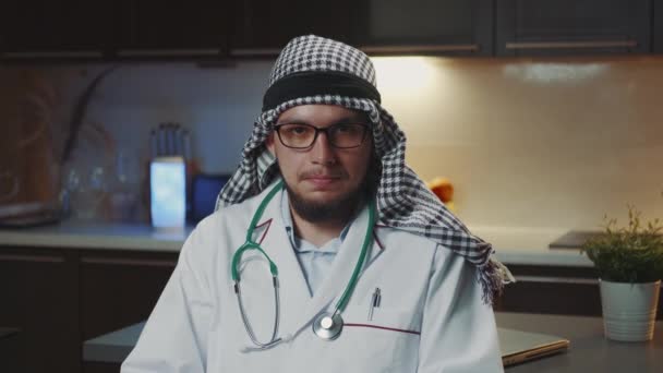 Arabski lekarz z kandora udzielanie wywiadu do kamery z domu — Wideo stockowe