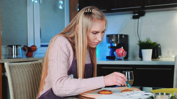 Mooie jonge vrouw leren om peperkoek koekjes versieren thuis — Stockfoto