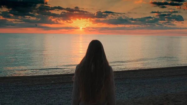 Primer plano de la mujer caminando hacia el mar y levantando las manos —  Fotos de Stock