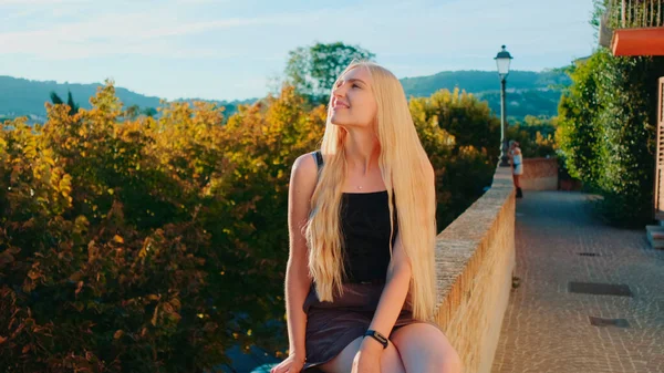 Jeune femme blonde relaxante et souriante aux rayons du soleil — Photo