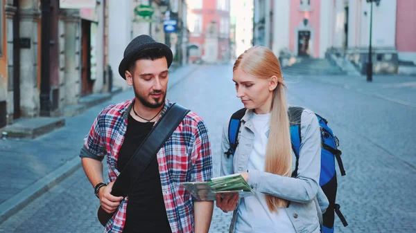 Happy young tourist couple with map walking and looking at old city architecture — Stock Photo, Image