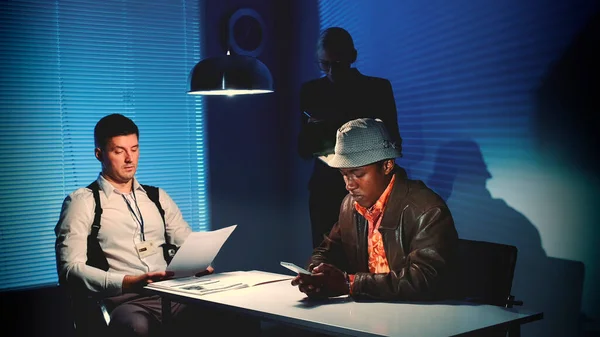 Multiracial desperate criminal writing last message on smartphone in interrogation room. — 스톡 사진