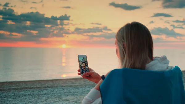 Jeune femme faisant appel vidéo à son ami avec smartphone sur la plage — Photo