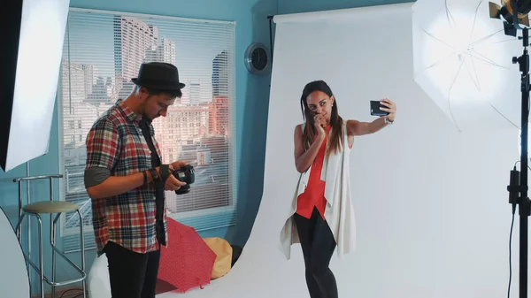Modelul destul de negru face selfie pe smartphone în timpul fotografiei în studioul modern — Fotografie, imagine de stoc