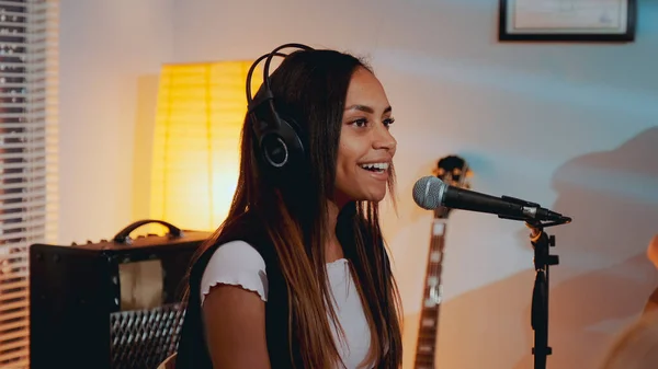 Close-up of beautiful smiling girl in headphone singing her favourite song on the rehearsal — Stock Photo, Image