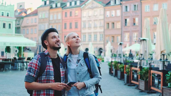 Молода пара туристів використовує смартфон і захоплюється красивим оточенням Ліцензійні Стокові Фото