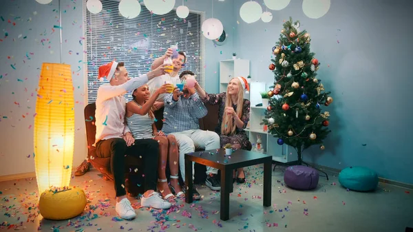 Natal tempo de festa de jovens felizes em confetes soprando — Fotografia de Stock