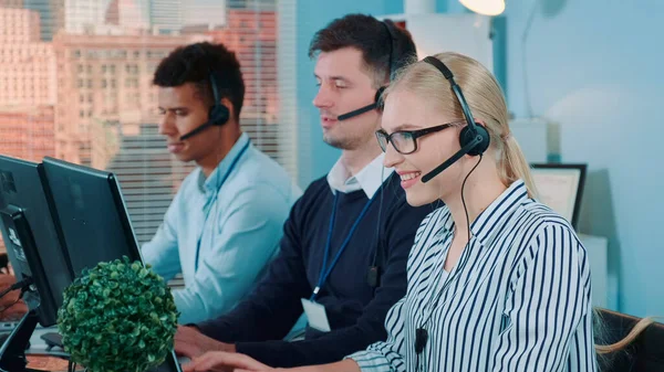 Medium shot of female customer service working in busy call center by talking to the international client