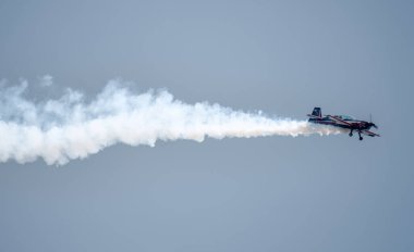 Kubinka, Moskova Bölgesi, Rusya - 12 Mayıs 2021: Mavi gökyüzünün arka planında dumanlı bir uçağın silueti. Hava gösterisi arka planı.