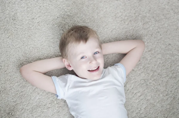 Niño en casa en una alfombra —  Fotos de Stock