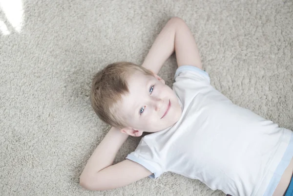 Little kid at home on a carpet — Stock Photo, Image