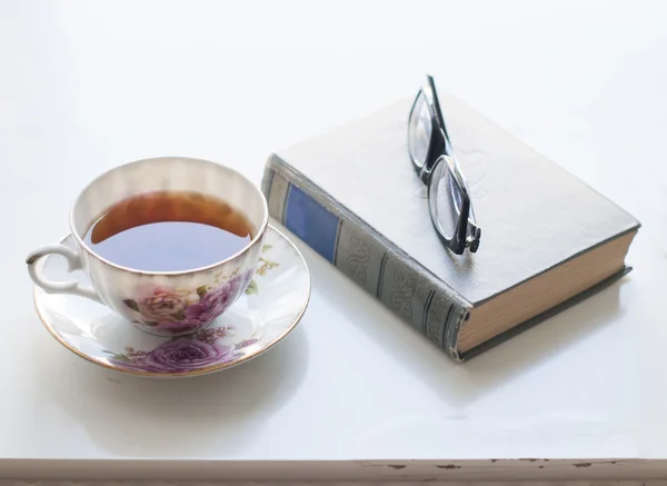 Taza de té, libro viejo y vasos — Foto de Stock