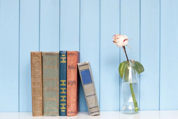 Σωρό βιβλία και το λευκό τριαντάφυλλο στο μπουκάλι — Φωτογραφία Αρχείου