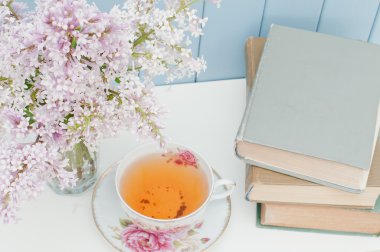 Leylak, kitaplar ve çay fincanı