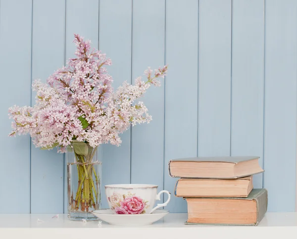 Bunch of lilac, books and teacup — Stock Photo, Image