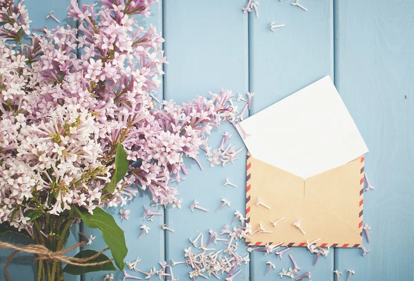 Vintage postage envelope with card and summer bouquet of lilac — Stock Photo, Image