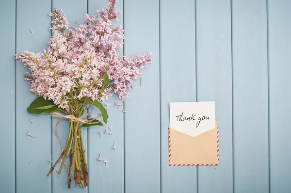 Vintage postage envelope with card and summer bouquet of lilac — Stock Photo, Image