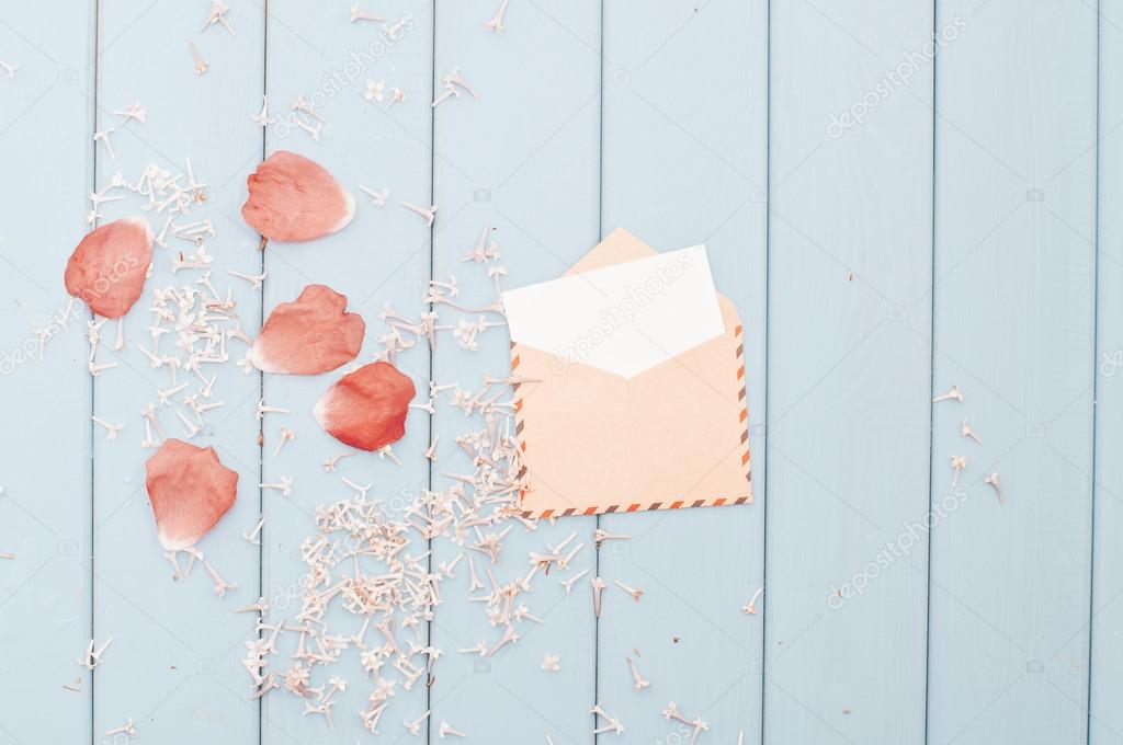 Flower petals and card in vintage postage envelope