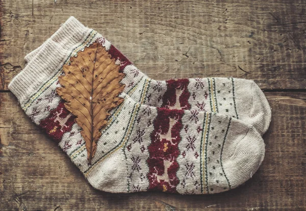 Knitted woolen socks and oak leaf — Stock Photo, Image