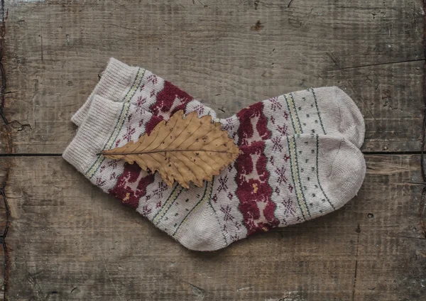 Knitted woolen socks and oak leaf — Stock Photo, Image